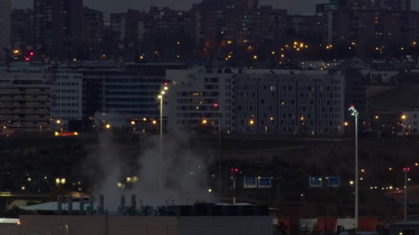 夕暮れ時のマドリードの街並み 前景に工場がある住宅や工業地帯の都市景観 パイプから煙が出てくる — ストック動画