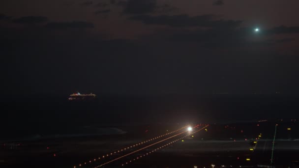 在夜空和大海的背景下 客机在机场着陆 游轮上点着灯光 — 图库视频影像