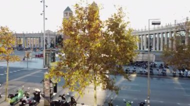 İspanya 'nın Barselona kentindeki parlak sabah güneşine karşı İspanya Meydanı' ndaki Venedik Kuleleri 'nin hava manzarası ile cadde boyunca park etmiş scooterlar.