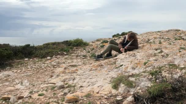 Junge Ruht Sich Auf Dem Felsigen Hügel Aus Und Schlägt — Stockvideo