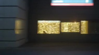 Şehir manzarası sokak lambalarıyla aydınlatılmış hareket eden bir metro treni, farları açık geçen arabalar, parlak reklam panoları, parlak binaların pencereleri, parlak ışıklandırılmış bir Noel ağacı, kış