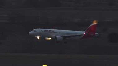 MADRID, SPAIN - 07 Aralık 2021: Madrid Barajas Havaalanı, akşam görüşü için İberya Havayolları 'nın 320 numaralı yolcu uçağı geliyor. İspanyol bayrak taşıyıcısı