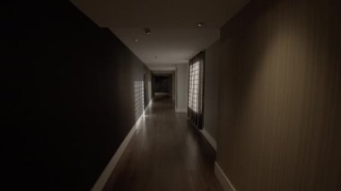 Boş otel koridorunda yürüme görüntüsü. Ayık renklerle iç içe, karanlık ve aydınlık gibi. Duvarlardan gelen güneş ışığı
