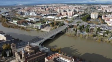 ZARAGOZA, İspanya - 23 Kasım 2021: Ebro Nehri ve Santiago Köprüsü ile havadan şehir manzarası. San Juan de los Panetes Kilisesi ve yerleşim yerleriyle sonbahar sahnesi