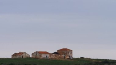 Terk edilmiş yarım yamalak çiftlik binaları açık gökyüzüne karşı çorak arazide. Terk edilmiş bölge