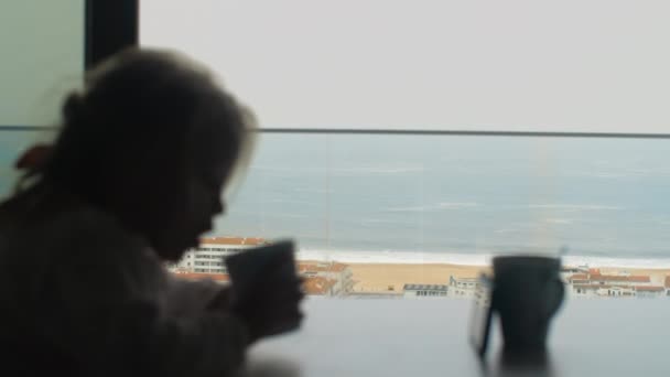 Child Drinking Morning Tea Watching Cartoons Phone Focus Ocean Beach – Stock-video