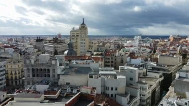 MADRID, SPAIN - 27 Kasım 2021: Ev çatıları ve yüksek binalar, Alcala caddesiyle şehir manzarası ve bulutlu gökyüzü