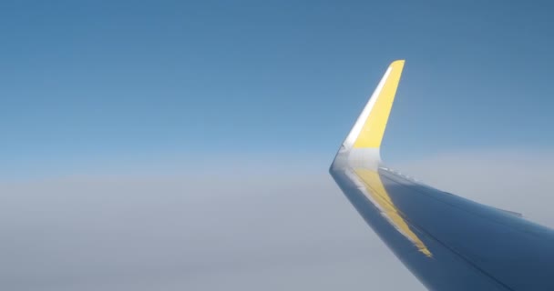 Een Vliegtuigvleugel Met Knipperende Parkeerlichten Boven Wolken Tegen Een Blauwe — Stockvideo