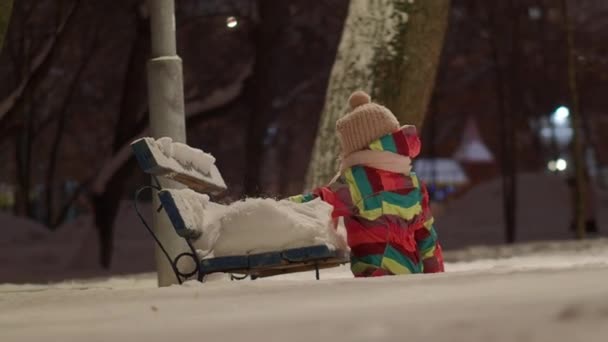 Девушка Цветном Комбинезоне Теплой Шляпе Гуляет Парку Зимним Вечером Играет — стоковое видео