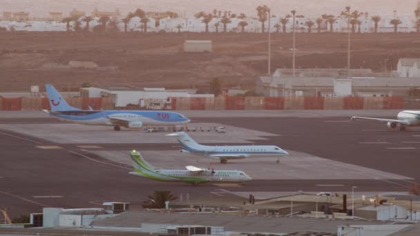 ランサローテ スペイン 2022年12月26日 空港に着陸した旅客用飛行機は 日没の空を背景に 立っている飛行機 公用車を通過して駐車場に課税されています — ストック動画