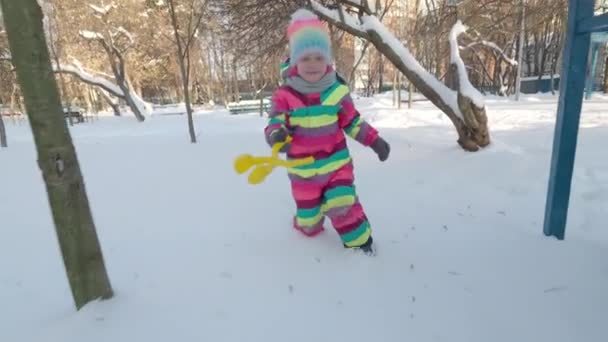 Little Girl Bright Overalls Warm Hat Walks Snow Playground Morning — Stockvideo