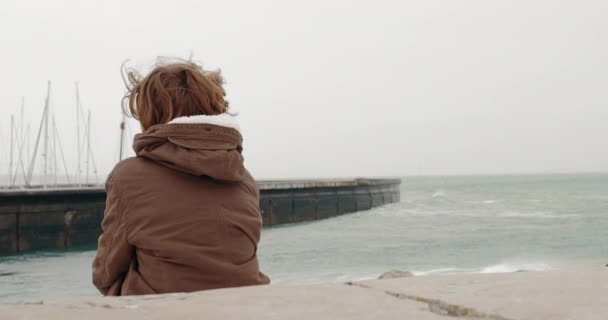 Back View Boy Warm Jacket Sitting Alone Coast Watching Ocean — Video Stock