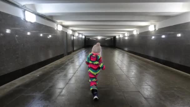 Back View Little Girl Winter Overclothes Walking Alone Underground Walkway — Stockvideo
