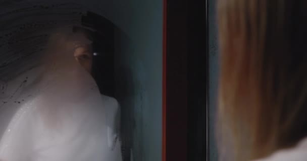 Mulher Loira Limpando Espelho Fumegante Olhando Para Mesma Com Insatisfação — Vídeo de Stock