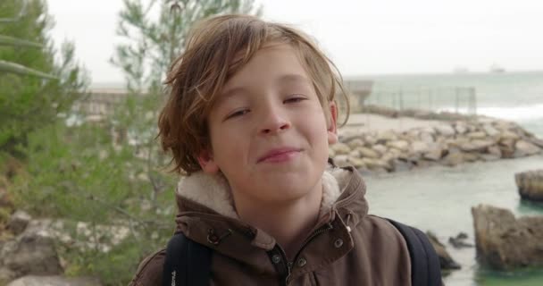 Close Portrait Smiling Boy Backpack Sea Scene Rocks Breakwater Young — Vídeos de Stock