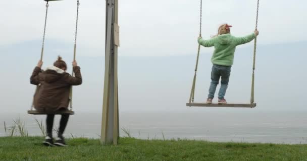 Boy Girl Swings Front Ocean Brother Sister Looking Water Scene — Αρχείο Βίντεο