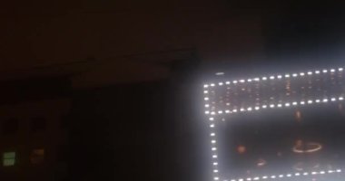 Gece şehrinde seyahat etmek. Sisli caddedeki arabanın camından bakarken karanlıkta binalar geçiyor.