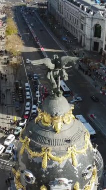 Victoria Alada heykeliyle Metropolis Binası 'nın dikey görüntüsü. Araba trafiğiyle Calle de Alcala 'ya bakın. Madrid sahnesi, İspanya