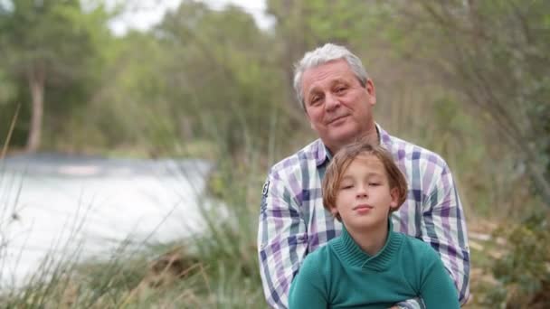 Portrait Grandfather Grandson Nature Background Grandpa Hugging Grandchild Both Looking — Stockvideo