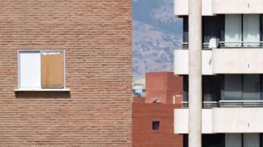 Details of urban architecture. Apartment house neighboring brick buildings in the city, mountains in background. View with hot air distortion