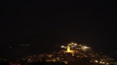 Small and quiet town on the hill at night. Illuminated buildings of Polop in the darkness, Spain