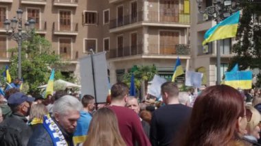 VALENCIA, İspanya - 25 Mart 2022: Vladimir Putin 'e karşı protesto ve şehir merkezindeki insanların katıldığı Ukrayna' nın Rus işgali. İnsanlar meydanda el sallıyor.