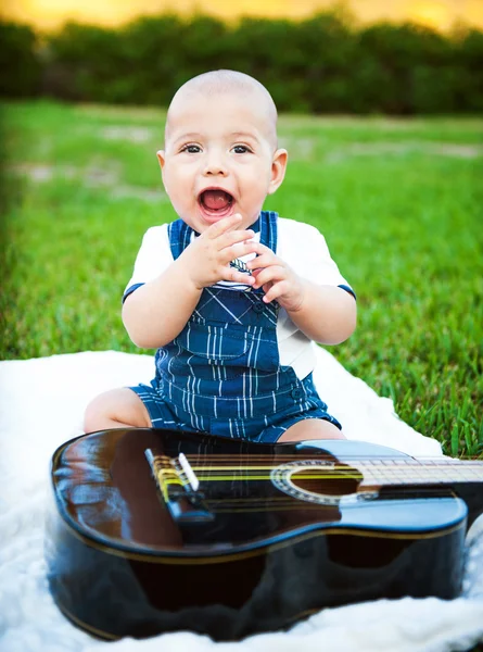 Bambino con una chitarra sull'erba — Foto Stock