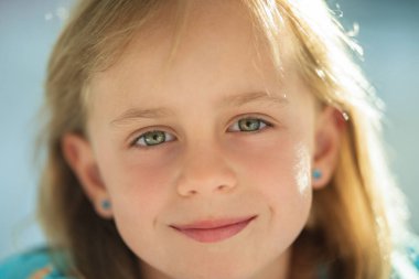 Parkta gülümseyen sevimli küçük kız.