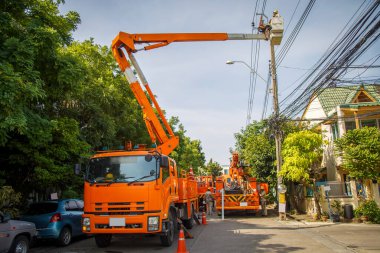 Turuncu vinç asansörü, köydeki elektrik direğini tamir etmesi için kovayla işçi gönderiyor.