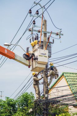 Nonthaburi, Tayland - 19 Mayıs 2021: Elektrikçi sokak lambalarındaki kabloları tamir ediyor.