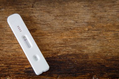 Tahta tablo üzerinde COVID-19 için hızlı test aygıtı kullanarak ve kopyalama alanı için boş bırakarak negatif test sonucu.