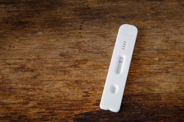 Tahta tablo üzerinde COVID-19 için hızlı test aygıtı kullanarak ve kopyalama alanı için boş bırakarak negatif test sonucu.