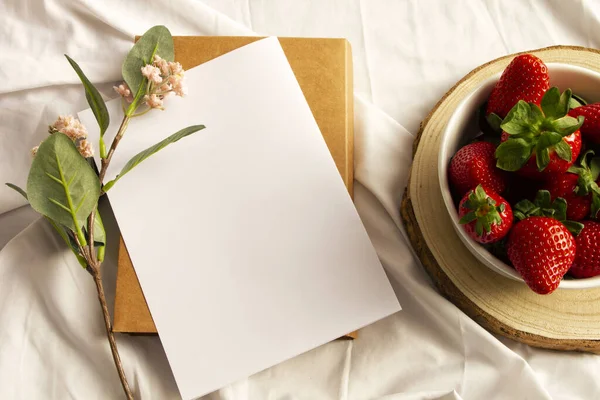 白纸上的空白笔记本 鲜花和草莓 平躺在地上 俯瞰四周 — 图库照片#