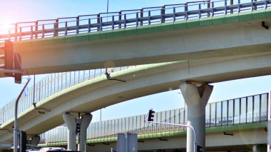 Mavi gökyüzüne karşı köprü. Otoyol üstgeçidi. Güneşli bir günde yükseltilmiş yollar.