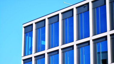 Gökyüzü arka planında cam cepheli modern ofis binası. Ofis binasının şeffaf cam duvarı.