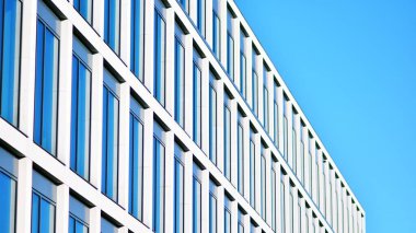 Gökyüzü arka planında cam cepheli modern ofis binası. Ofis binasının şeffaf cam duvarı.