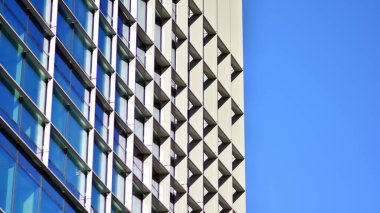 Gökyüzü arka planında cam cepheli modern ofis binası. Ofis binasının şeffaf cam duvarı.