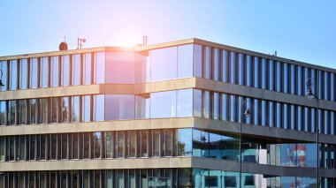 Gökyüzü arka planında cam cepheli modern ofis binası. Ofis binasının şeffaf cam duvarı.