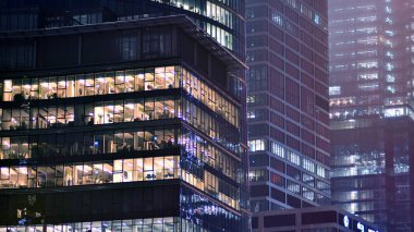 Geceleri şirket binası, iş konsepti. Camdan ofis binası. Geceleri parlayan modern gökdelen ofis pencereleri..