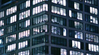 Geceleri şirket binası, iş konsepti. Camdan ofis binası. Geceleri parlayan modern gökdelen ofis pencereleri..