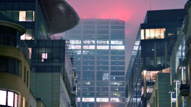 Geceleri şirket binası, iş konsepti. Camdan ofis binası. Geceleri parlayan modern gökdelen ofis pencereleri..