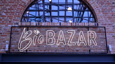 Varşova, Polonya. 8 Aralık 2021. Yeniden canlandırılmış Fabryka Norblina, butikler, dükkanlar, eşsiz moda ve gastronomik kavramlarla dolu, açık ve canlı bir alandır. Neon işareti BiyoBazar.