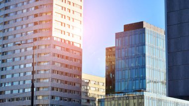 Ticari bina mavi tonda kapanıyor. Aşağıdan devasa bir gökdelen. Modern bina ve cam cephesinin mimari detayları. Güneşli bir günde iş geçmişi. 