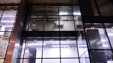 Geceleri ofis binası, cam ve ışıklarla dolu bir bina. Aydınlatılmış modern gökdelen ile arka plan.