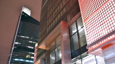 Geceleri ofis binası, cam ve ışıklarla dolu bir bina. Aydınlatılmış modern gökdelen ile arka plan.