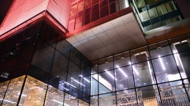 Geceleri ofis binası, cam ve ışıklarla dolu bir bina. Aydınlatılmış modern gökdelen ile arka plan.