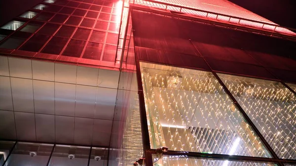 Geceleri ofis binası, cam ve ışıklarla dolu bir bina. Aydınlatılmış modern gökdelen ile arka plan.
