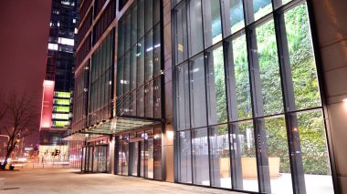 Varşova, Polonya. 8 Ocak 2022. Gece mimarisi, cam cepheli gökdelen. İş bölgesinde modern bir bina. Ekonomi kavramı, finans. Jenerasyon Parkı karmaşık bir ofis binasıdır..