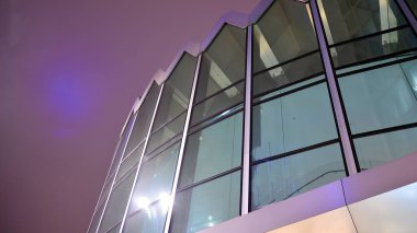 Office building at night, building facade with glass and lights. View with illuminated modern skyscraper.
