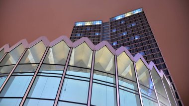 Office building at night, building facade with glass and lights. View with illuminated modern skyscraper.